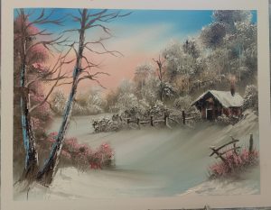 Snowy forest scene with small cabin